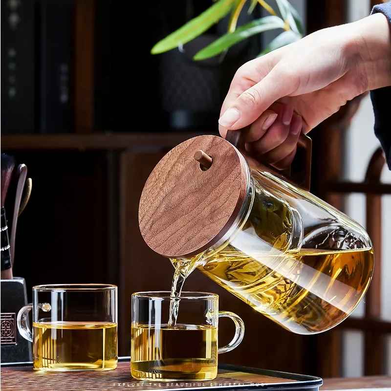 Comfort Life Separation Teapot pouring tea into cups with wooden lid and borosilicate glass design.