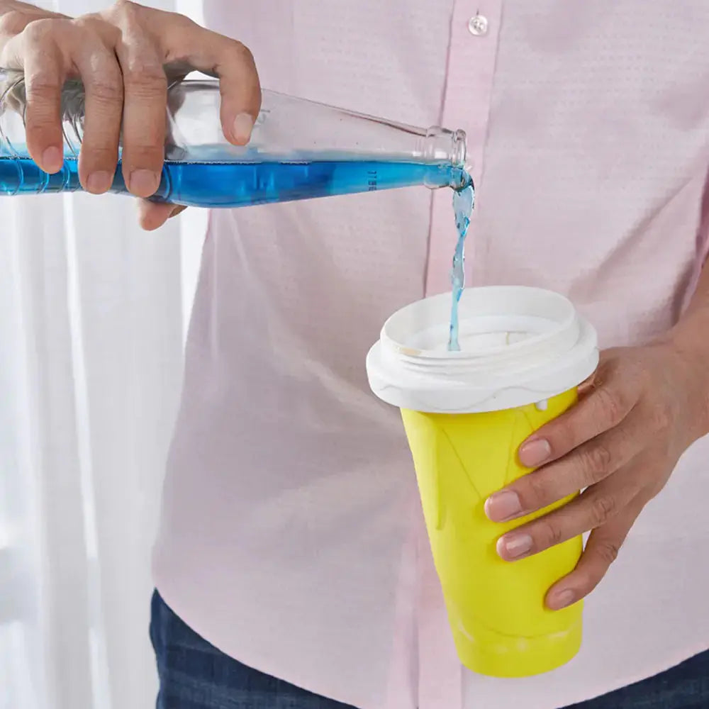 Person pouring blue liquid into a yellow Comfort Life smoothie cup.